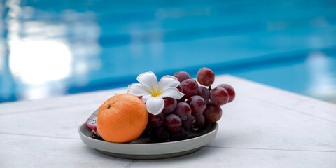 Fruits in a tray by the hotel's pool, healthy food concept