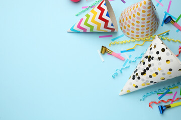Obraz premium Flat lay composition with party hats and other festive items on light blue background. Space for text