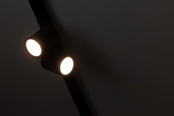Fototapeta na wymiar Two spot lights in black body mounted on ceiling