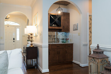 Built in bar, cocktail station, arched doorway, walnut cabinets in living room
