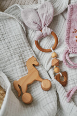 Fototapeta na wymiar Hobbies and handicrafts. Knitted beanie with handmade embroidery. Wooden toys, rattles, teethers, nipple holder. Baby development, fine motor skills. Children and newborn products and accessories.
