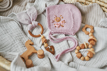 Fototapeta na wymiar Hobbies and handicrafts. Knitted beanie with handmade embroidery. Wooden toys, rattles, teethers, nipple holder. Baby development, fine motor skills. Children and newborn products and accessories.