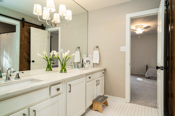 All white vanity with natural wood barn door feature