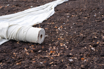 A roll of rolled white geotextile on the ground.