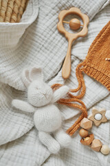 Fototapeta premium Hobbies and handicrafts. Knitted beanie with handmade embroidery. Wooden toys, rattles, teethers, nipple holder. Baby development, fine motor skills. Children and newborn products and accessories.