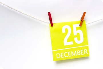 December 25th. Day 25 of month, Calendar date. Paper cards with calendar day hanging rope with clothespins on white background. Winter month, day of the year concept.