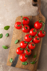 Tomatoes on a brown background. Italian food. A fresh crop of vegetables. Cherry tomatoes and basil. Organic food