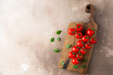 Tomatoes on a brown background. Italian food. A fresh crop of vegetables. Cherry tomatoes and basil. Organic food