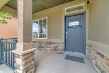 Front porch with security camera above the gray front door with window panel and lockbox