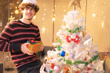 Cheerful friends decorating Christmas tree.Group of young friends sitting next to a nicely decorated Christmas tree, exchanging Christmas presents.