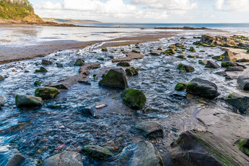 A view down a stream at Coppet Hall beach at Saundersfoot, South Wales on a sunny day
