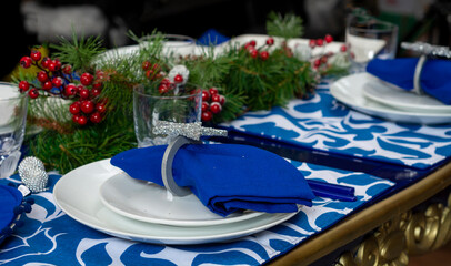 table with blue Christmas decoration, with crockery and glassware for Christmas dinner