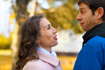 Fototapeta premium Romantic couple posing in an autumn park. Beautiful nature and trees with yellow leaves.