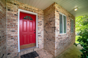 Fototapeta premium Entrance exterior of a house with red door and bricks