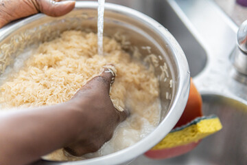 African American Nigerian woman washing rice before cooking