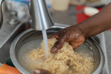 African American Nigerian woman washing rice before cooking
