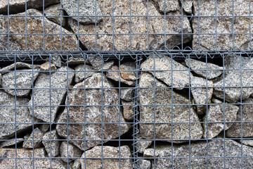 Abstract view to stone fence with metal net