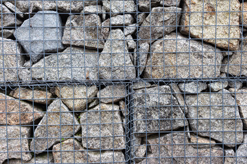 Abstract view to stone fence with metal net