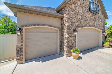 Double arched sectional garage doors with potted plants outside