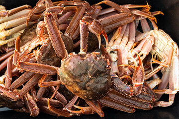 crab and crab legs on the flat black table
