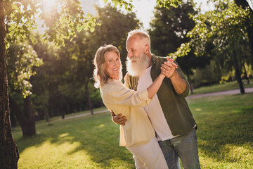 Obraz premium Portrait of attractive cheerful middle-aged couple life partners dancing spending free time vacation on fresh air outdoors