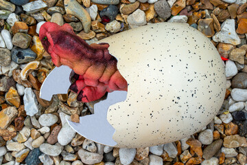 Red dinosaur emerging from an egg