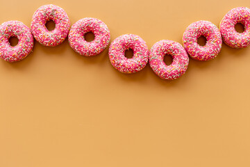 Set of pink glazed donutes with sprinkles, top view