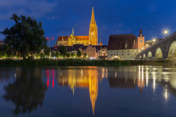 Regensburg. The old cathedral on the city embankment near the Danube river at night.