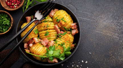 Baked potatoes with ham, herbs and breadcrumbs on dark background. Scandinavian cuisine. Top view.
