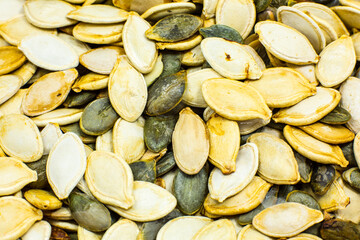 Dry Roasted Pumpkin seeds background. Tasty and healthy food. Close up photo.
