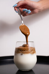 Coffee cream pouring in a glass of milk