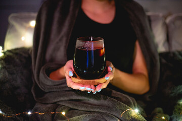Girl holding glass of mulled wine at home