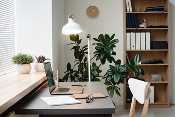Image of workplace of office worker with laptop on it at modern office