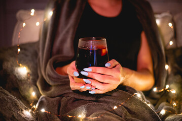 Girl holding glass of mulled wine at home