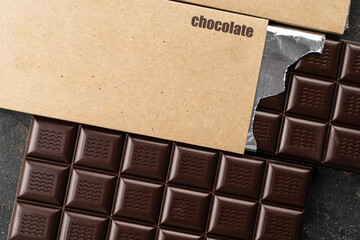 Handmade chocolate. Black bitter craft chocolate bar on a black background. Healthy food concept, delicious chocolate sweets, diet, sugar