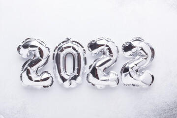 Silver balloons in the form of numbers 2022 on white background. New year celebration. Happy New Year 2022 concepts.