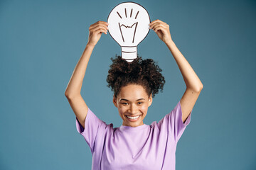 Portrait of multiracial woman holding lamp sing, looking inspired by genius thought