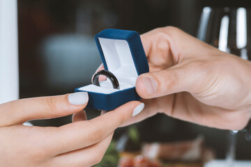 Male hands with blue velvet box containing payments smart ring