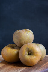 Pippin apples close-up, on wooden table, selective focus, gray background, vertical, with copy space