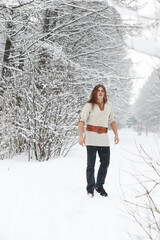 Outdoor portrait of handsome man in coat and scurf. Bearded man in the winter woods.