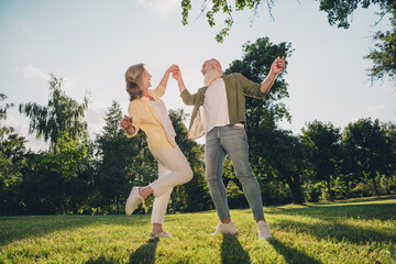 Full length photo of happy joyful old people feel young dance crazy together spring enjoy outside...