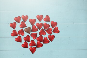 Red chocolate sweets as heart on background. Valentine's day concept.