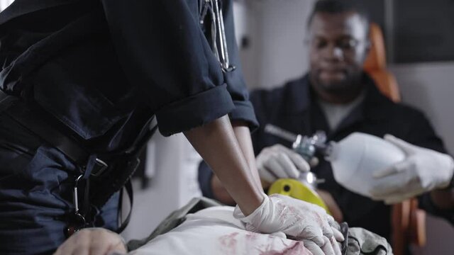 Ambulance crew doing heart massage for man inside car