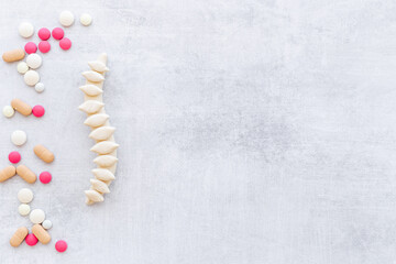 Anatomical spine skeleton with medical pills. Spinal diseases treatment concept