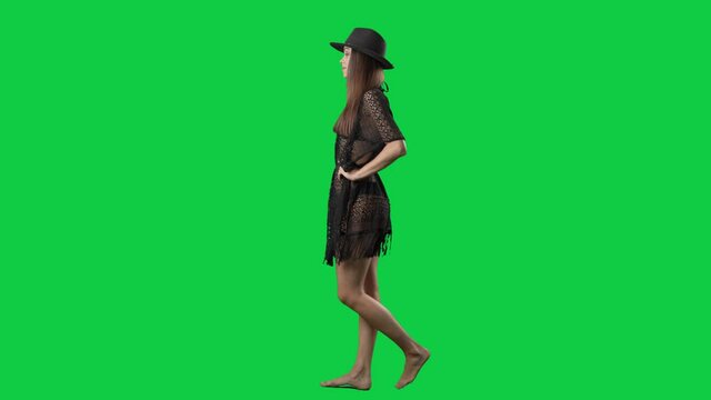 Confident attitude beach wear fashion girl walking. Side view. Full body isolated on green screen background