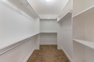 Empty walk-in closet shelving units with metal rods