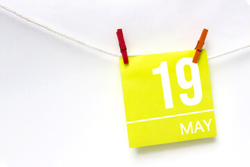 May 19th. Day 19 of month, Calendar date. Paper cards with calendar day hanging rope with clothespins on white background. Spring month, day of the year concept.