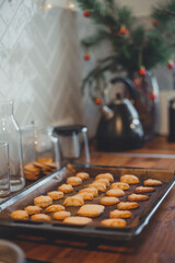 Homemade Christmas cookies on a baking sheet on a wooden table.