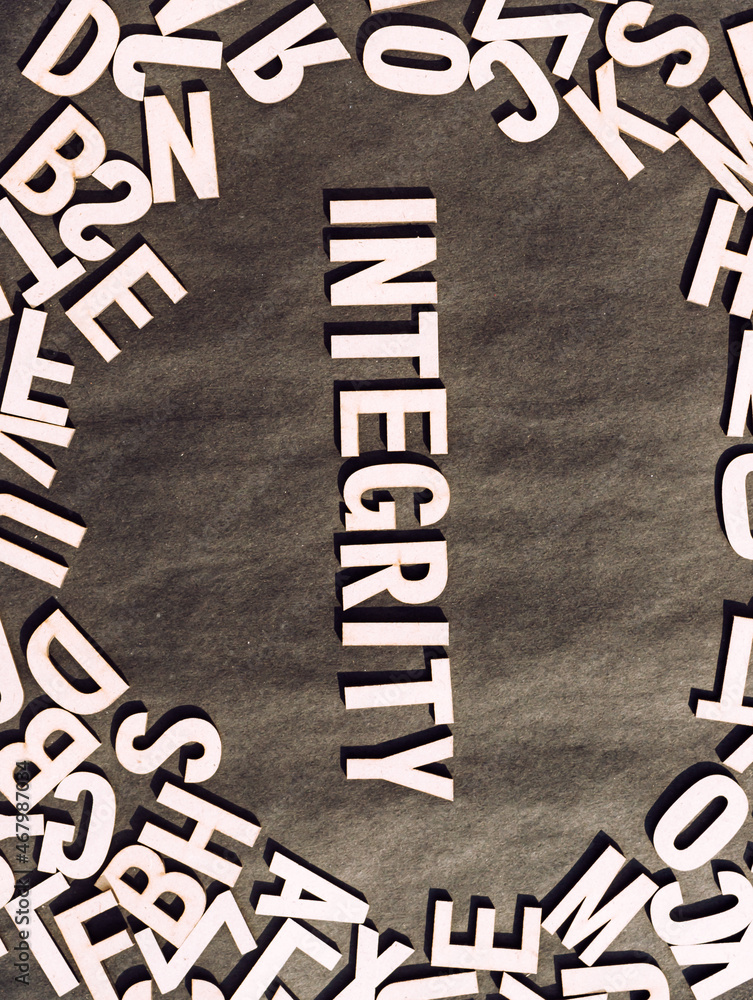 Fototapete integrity word in wooden cube alphabet letters top view on a rustic paper background.