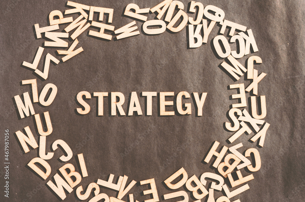 Fototapete strategy word in wooden cube alphabet letters top view on a rustic paper background.